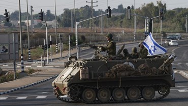 عناصر من القوات الإسرائيلية يعبرون طريقا رئيسيا مع انتشار قوات إضافية بالقرب من مدينة سديروت الجنوبية (8 ت1 2023، أ ف ب).