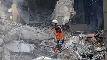 منقذ فلسطيني وقف وسط أنقاض مبنى مدمر في خان يونس جنوب قطاع غزة في أعقاب قصف إسرائيلي ليلي (10 ت1 2023، أ ف ب). 