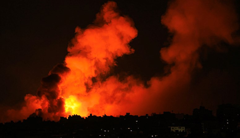 انفجارات تضيء السماء أثناء الغارات الإسرائيلية على مدينة غزة في 10 تشرين الأول 2023 (أ ف ب).