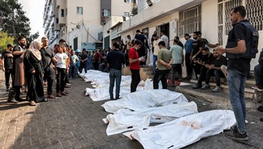  جثث ضحايا الغارات الجوية الإسرائيلية خارج مشرحة مستشفى الشفاء (أ ف ب).
