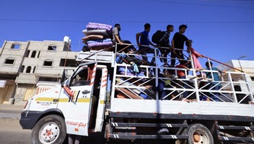 شاحنة تنقل عائلة فلسطينية وممتلكاتها إلى خان يونس جنوب قطاع غزة (15 ت1 2023، أ ف ب). 