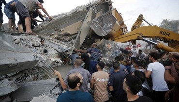 رجال انقاذ يزيلون أنقاض منزل دمر في أعقاب هجوم إسرائيلي على بلدة دير البلح وسط قطاع غزة (15 ت1 2023، أ ف ب).