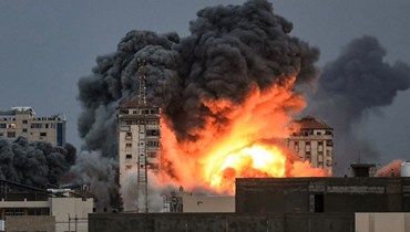 كرة نار فوق مبنى في قطاع غزة، جرّاء غارة جوّية إسرائيلية (7 ت1 2023 - أ ف ب).