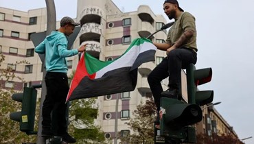 يحملان العلم الفلسطيني في برلين. (رويترز)