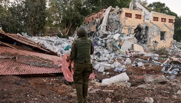 جندي إسرائيلي يقف أمام منزل مدمّر. (أ ف ب)