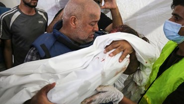 مراسل "الجزيرة" وائل الدحدوح يحمل جثة أحد أبنائه (أ ف ب). 