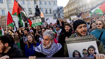 متظاهرون في وارسو يرددون شعارات خلال مسيرة تضامنية مع الفلسطينيين في غزة (29 ت1 2023، أ ف ب). 