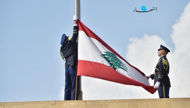 جنديّان من الحرس الجمهوري يعملان على إنزال العلم اللبناني عن القصر الجمهوري بعد خلوّه من رئيس (نبيل اسماعيل).
