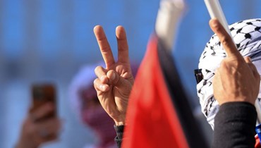 متظاهر يرفع علامة السلام دعماً للشعب الفلسطيني خلال مسيرة في وسط مدينة لوس أنجلوس (أ ف ب). 