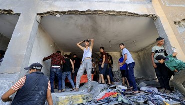 فلسطينيون يتفقدون الاضرار بعد غارة جوية إسرائيلية على خان يونس في جنوب قطاع غزة (3 ت2 2023، أ ف ب).