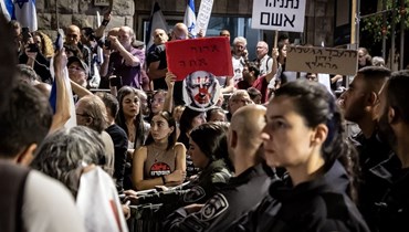 متظاهرون إسرائيليون يرفعون لافتات ضدّ رئيس الوزراء بنيامين نتنياهو خلال مظاهرة مناهضة للحكومة في القدس (4 ت2 2023 - أ ف ب).