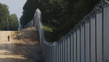 صورة ارشيفية- جندي من حرس الحدود البولندي يقوم بدورية في منطقة على الحدود بين بولندا وبيلاروسيا، بالقرب من كوزنيتسه في بولندا (30 حزيران 2022، أ ب). 