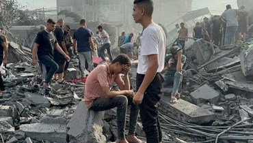 فلسطينيون يبحثون عن ناجين بعد غارة جوية إسرائيلية على مخيم النصيرات للاجئين في قطاع غزة (31 ت1 2023، أ ف ب).