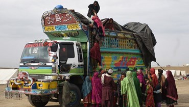 لاجئون أفغان يصعدون الى شاحنة في تشامان لعبور الحدود الباكستانية الأفغانية (7 ت2 2023، أ ف ب).