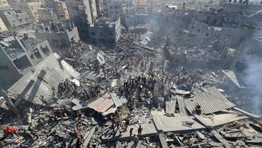 فلسطينيون يبحثون عن ناجين وجثث ضحايا بين أنقاض المباني التي دمرت خلال القصف الإسرائيلي في خان يونس بجنوب قطاع غزة (26 تشرين الأول - أ ف ب).