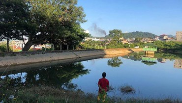 رجل ينظر الى دخان يتصاعد من اتجاه قاعدة عسكرية بورمية في بلدة لاشيو بولاية شان الشمالية (7 ت2 2023، أ ف ب).