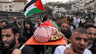 مشيّعون يحملون جثّة رجل فلسطيني قُتل بالرصاص أثناء قيادته لسيارة أجرة خلال عملية عسكرية شنتها القوات الإسرائيلية في الضفة الغربية (أ ف ب).