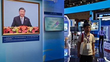 صورة لشي رفعت بينما يزور اشخاص جناح الصين في معرض الصين الدولي السادس للاستيراد في شنغهاي (5 ت2 2023، أ ف ب).