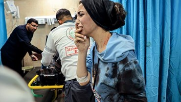  امرأة فلسطينية مصابة وقفت في غرفة الطوارئ بمستشفى الأقصى عقب قصف إسرائيلي على دير البلح وسط قطاع غزة (15 ت2 2023، أ ف ب).