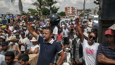 انصار يهتفون بينما يمر أعضاء مجموعة مرشحي المعارضة في شوارع منطقة أنالاماهيتسي في أنتاناناريفو (14 ت2 2023، أ ف ب).