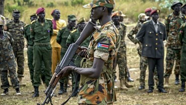 جندي من جنوب السودان يراقب المنطقة بينما تشارك قوات تابعة للقوات الموحدة لجنوب السودان في احتفال انتشار في مركز لوري للتدريب العسكري في جوبا (15 ت2 2023، أ ف ب). 