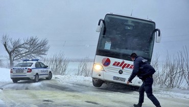 شرطي يمشي قرب حافلة خرجت عن الطريق بالقرب من بلدة دوبريتش في بلغاريا (19 ت2 2023، أ ب). 