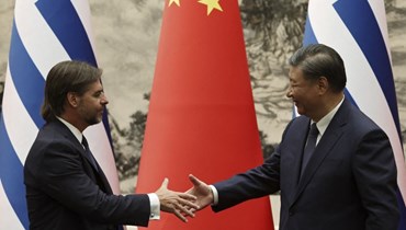 رئيس الأوروغواي لويس لاكال بو والرئيس الصيني شي جينبينغ يتصافحان خلال احتفال توقيع في قاعة الشعب الكبرى في بيجينغ (22 ت2 2023، أ ف ب). 