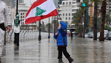 طفل يرفع العلم اللبناني في الكورنيش البحري في بيروت (حسام شبارو).
