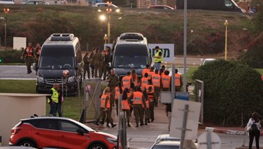 قوات الأمن الإسرائيلية تقف بجوار الحافلات في تل أبيب، وسط الاستعدادات لإطلاق سراح الرهائن الإسرائيليين الذين تحتجزهم حماس (أ ف ب). 