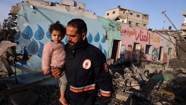 أطفال يسيرون وسط أنقاض مدرسة أصيبت خلال غارة إسرائيلية (24 تشرين الثاني 2023، أ ف ب).
