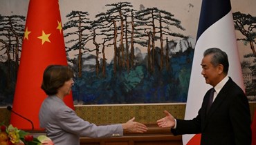 مصافحة بين وزير الخارجية الصيني وانغ يي (إلى اليمين) وكولونا بعد مؤتمر صحافي مشترك في بيجينغ (24 ت2 2023ـ أ ف ب).