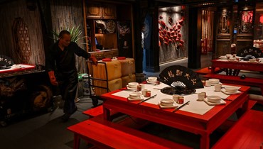 عامل يجمع الزيوت المستعملة لإعادة تدويرها من مطعم في مدينة تشنغدو في مقاطعة سيتشوان، جنوب غرب الصين (21 ت1 2023 - أ ف ب).