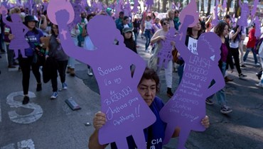 نساء يشاركن في تظاهرة في إطار اليوم العالمي للقضاء على العنف ضد المرأة في مكسيكو سيتي (25 ت2 2023، أ ف ب). 