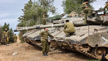 جنود إسرائيليون يقومون بصيانة الدبابات المنتشرة على الحدود الجنوبية مع قطاع غزة (28 ت2 2023، أ ف ب).