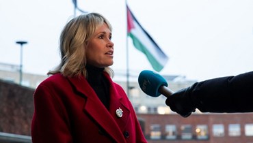 ليندبو تقف بجوار العلم الفلسطيني خلال اجراء مقابلة صحافية معها امام مقر البلدية في أوسلو (29 ت2 2023، أ ف ب). 