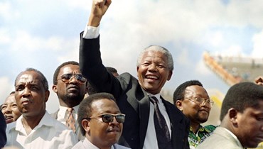مانديلا يحيي أنصاره لدى وصوله لحضور تجمع انتخابي في ماباثو (15 آذار 1994، أ ف ب). 