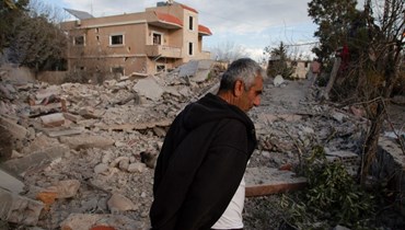 رجل يتفقد الأضرار التي خلفتها غارة إسرائيلية على بلدة ميس الجبل الحدودية بجنوب لبنان (6 ك1 2023، أ ف ب). 