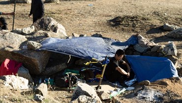 مهاجر صيني جلس أمام خيمته في مخيم للمهاجرين على الجانب الأميركي من الجدار الحدودي الذي يفصل المكسيك عن الولايات المتحدة في جاكومبا بكاليفورنيا (6 ك1 2023ـ أ ف ب). 
