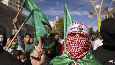 متظاهرون يرفعون أعلام حركة حماس خلال مسيرة بعد صلاة الجمعة في مدينة الخليل بالضفة الغربية المحتلة (8 ك1 2023، أ ف ب).