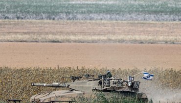 صورة ملتقطة في جنوب إسرائيل بالقرب من الحدود مع قطاع غزة، تظهر دبابة تابعة للجيش الإسرائيلي في أحد الحقول (8 ك1 2023، أ ف ب). 