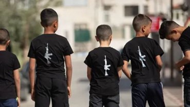 أطفال يرتدون قمصان عليها صور سلاح إم 16.