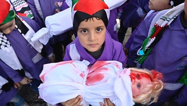 طفلة تحمل مجسّماً لجثة طفلة في غزّة أمام مبنى الاتحاد الأوروبي في بيروت (حسام شبارو).