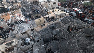 فلسطينيون يتفقدون الدمار الذي خلفه قصف إسرائيلي في رفح جنوب قطاع غزة (12 ك1 2023، أ ف ب).