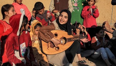عزف الموسيقى للأطفال الفلسطينيين، في نشاط يهدف إلى دعم صحتهم النفسيّة، وسط استمرار الحرب على غزة (أ ف ب). 