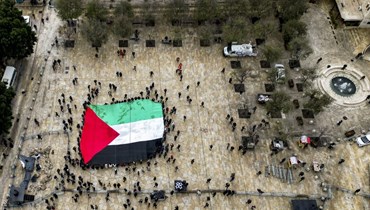 رفعُ العلم الفلسطيني في ساجة كنيسة المهد في بيت لحم مع غياب الاحتفالات في عيد الميلاد بسبب المأساة في غزّة (أ ف ب).