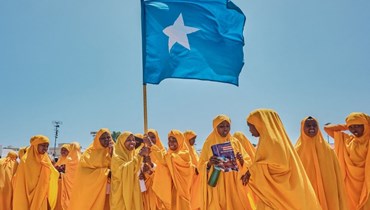 طالبات يلوحن بالعلم الصومالي خلال تظاهرة في ملعب إنغ ياريسو في مقديشو دعما للحكومة الصومالية في أعقاب الاتفاق الموقع بين إثيوبيا وأرض الصومال الانفصالية (3 ك2 2024، أ ف ب). 