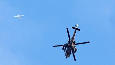 طائرة "أباتشي" إسرائيلية وأخرى مسيّرة تُحلّقان في سماء غزة (أ ف ب).