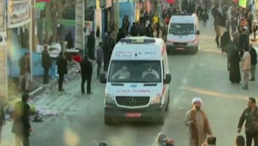 صورة مأخوذة من مقطع فيديو نشرته وكالة أنباء "إيران برس" تظهر سيارات إسعاف تغادر موقع الانفجارين في مدينة كرمان (أ ف ب). 