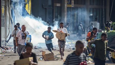 أناس ينهبون متاجر خلال أعمال شغب في بور مورسبي عاصمة بابوازيا-غينيا الجديدة (أ ف ب). 