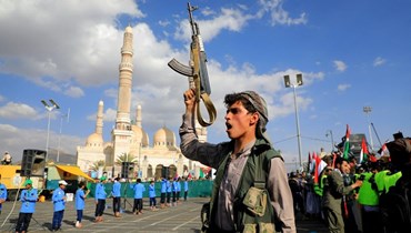 يمني يلوح بسلاحه خلال مسيرة تضامنية مع غزة في العاصمة صنعاء التي يسيطر عليها الحوثيون (5 ك2 2024 - أ ف ب).